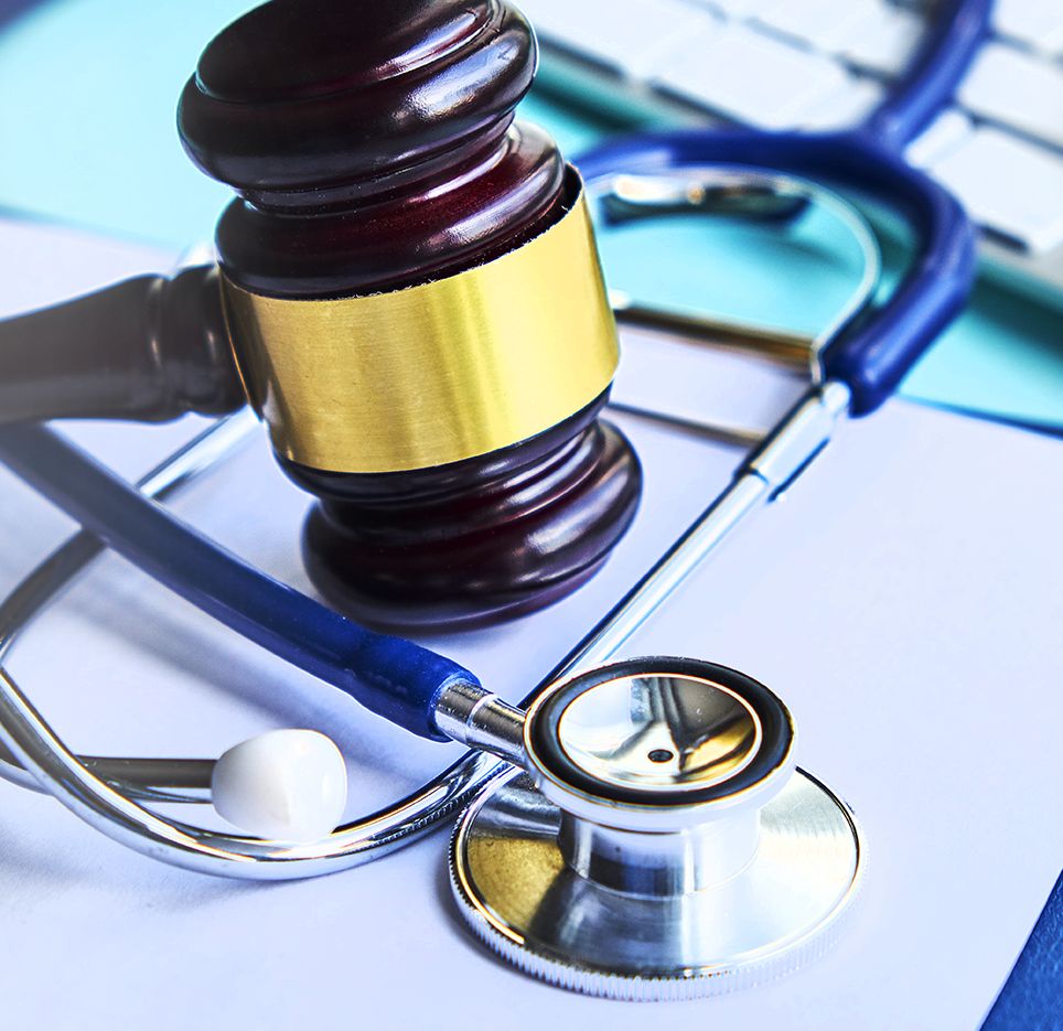 A judge 's gavel and stethoscope on top of papers.